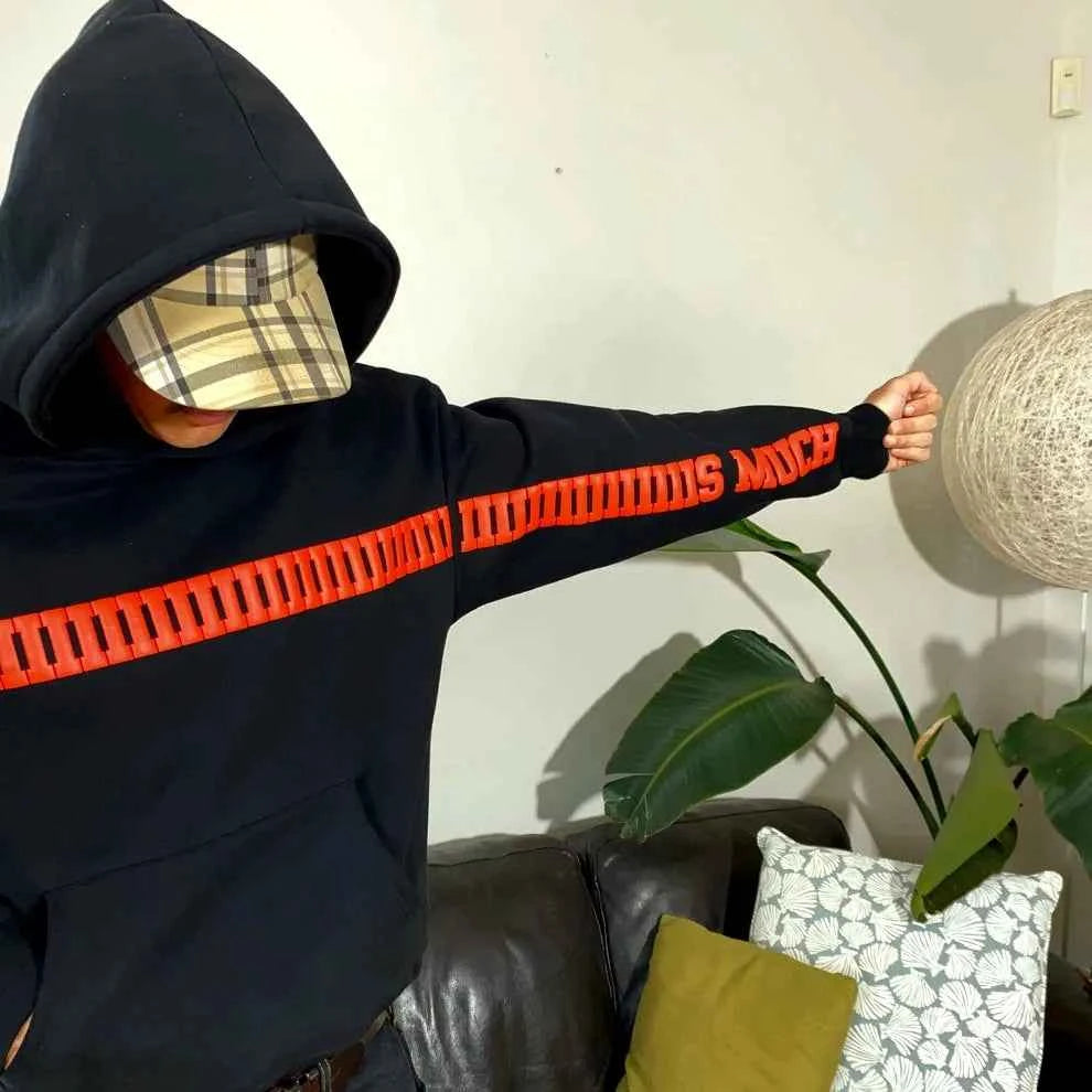 Elevate Your Style with the I Love You This Much Hoodie in Black by Xoratic, black hooded sweatshirt with red sleeve lettering shown indoors from the Hoodie collection