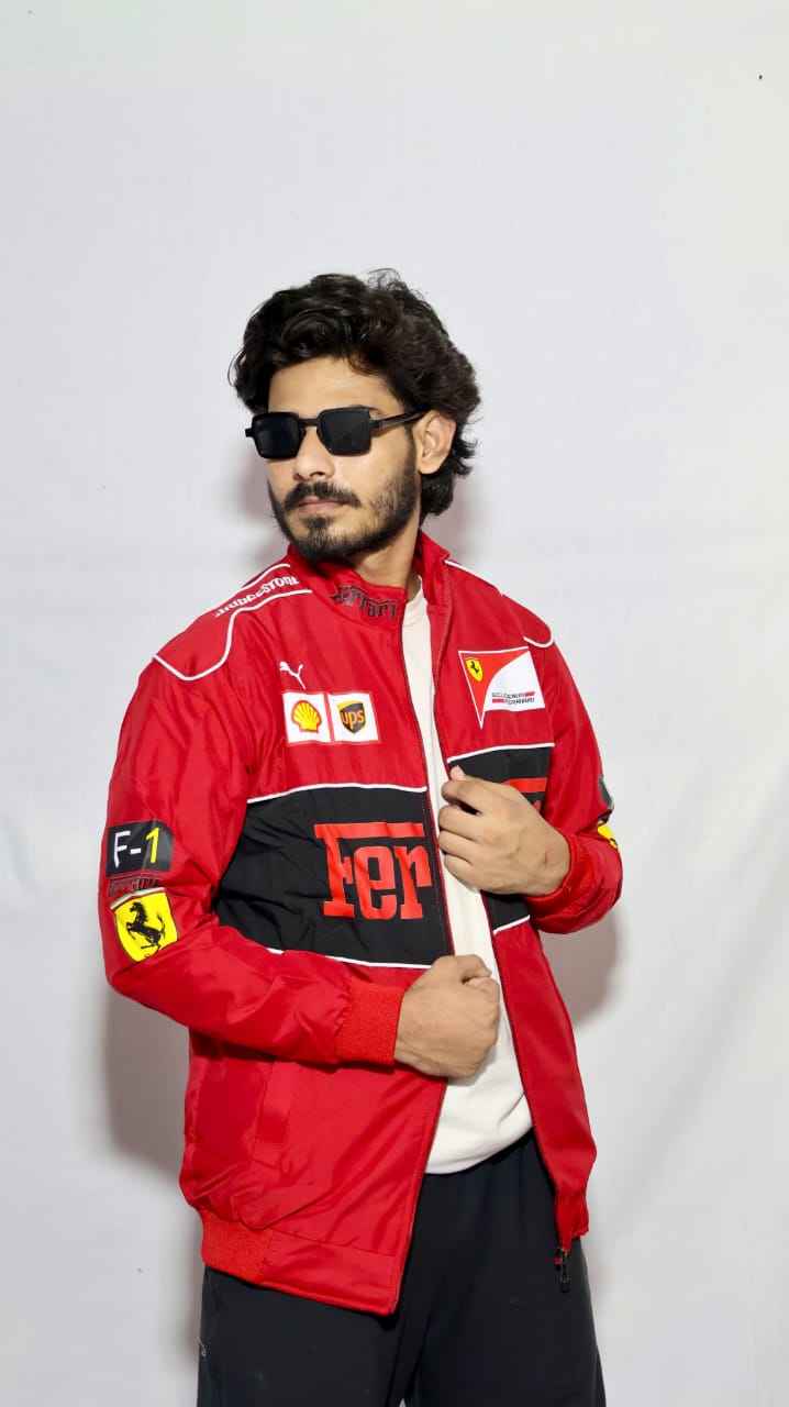Elevate Your Look with the Ferrari Racing Jacket in Bold Red worn by a man in sunglasses with racing patches from Xoratic