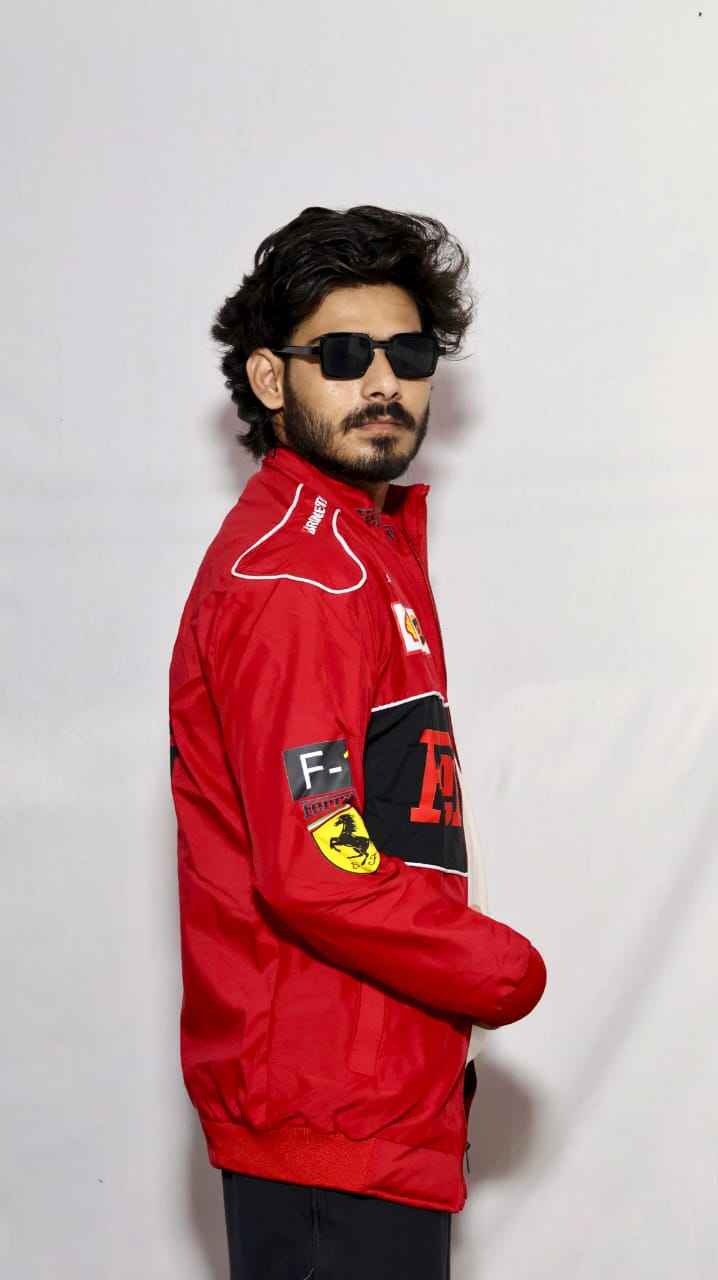 Elevate Your Look with the Ferrari Racing Jacket in Bold Red worn by a man with sunglasses, featuring racing patches and white detailing, by Xoratic in Trending Jackets collection