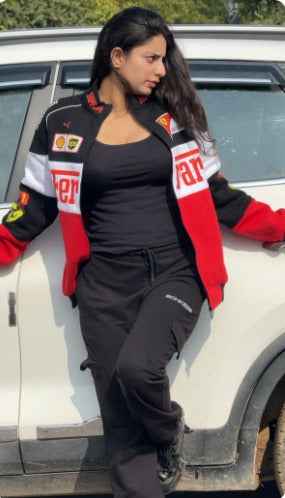 Ferrari Racing Jacket: Elevate Your Style with Tri-Colored Elegance worn by a woman beside a car, featuring red, black, and white racing details by Xoratic