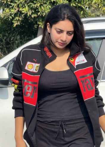 Ferrari Racing Jacket in Black - Embrace the Spirit of Motorsport worn by a woman outdoors, featuring red racing graphics, sponsor patches, and white piping